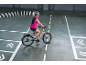 Woman in cycling gear on an electric bike, navigating a course with white lines and dominoes.