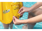 Yellow child's swim vest with «Swim Safe» text being fastened in a pool.