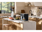Air fryer and food chopper on a kitchen island with salad and skewers.