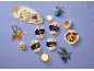 Assorted mini ice cream desserts (Mocha & Hazelnut, Peach & Vanilla, Banana & Caramel, Macadamia & Vanilla) on a purple background, festively decorated.