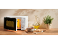 White microwave with open door, soup, bread, and oil in a rustic kitchen setting.