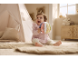 Smiling baby sitting on a play mat with a colorful fabric ball in front of a teepee.