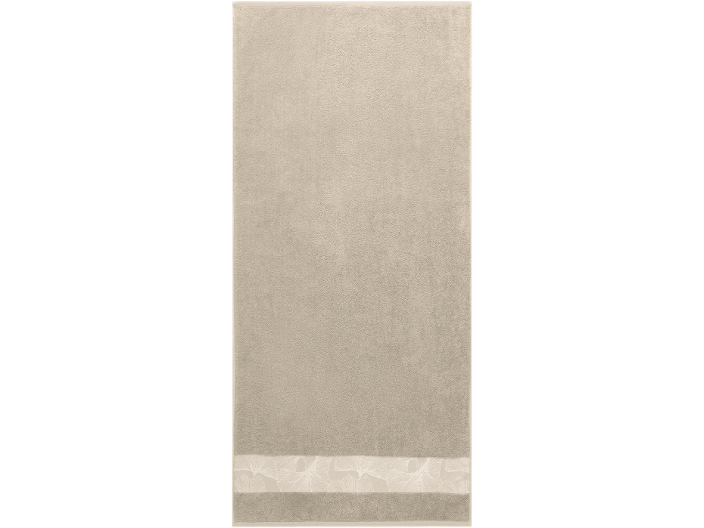 Beige towel with a decorative border featuring a ginkgo leaf pattern.