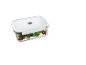 Transparent food container with a white lid, filled with salad, tomatoes, and cheese.