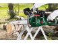 Person cutting a log with a chainsaw on a sawhorse outdoors.