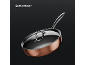Copper-colored frying pan with a glass lid and metal handle on a dark background.