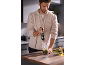 Man in kitchen preparing food with a corded immersion blender.