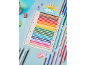 Grid notebook with colored pencils, sharpener, and paper decorations on a blue background.