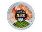 Latin American style prawns with a green chimichurri dip in a transparent container.