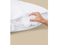Hand adjusting the filling of a white pillow with a zipper