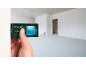 Laser distance measurer measuring distance in an empty room.