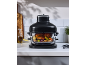 Air fryer with chicken and vegetables on a kitchen countertop.