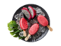 Red dragon fruit popsicles with ice and sliced dragon fruit on a dark plate.