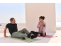 Man and woman on yoga mats, using massage tools.