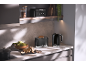 Black toaster and kettle with '1973' text in a modern kitchen.