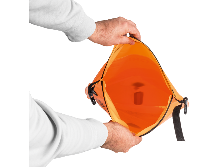 Hands opening an orange waterproof bag with a clip closure.