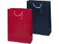 Two gift bags, one red and one navy blue, with white rope handles and gift tags.