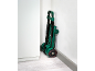 Foldable hand truck with elastic straps, stored upright in a corner.