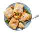 Sweet filo pastry squares with powdered sugar, mint, and watermelon pieces on a blue plate.