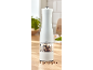 White electric pepper grinder with a transparent compartment filled with peppercorns.