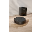 Robot vacuum cleaner and automatic emptying station on a wooden floor with water stains.
