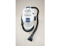 White and blue carpet and upholstery cleaner with black hose and nozzle, on a light carpet.