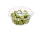 Green olives with pits in a clear plastic container.
