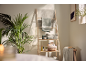 Wooden towel rack with bath towels, personal care products, and a plant.