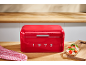 Red bread bin with the number 1973, checkered towel, and toast with tomato.