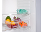 Refrigerator with water bottles and clear containers filled with fruits and vegetables.