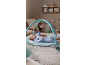 Baby playing on an activity mat with hanging toys.