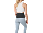 Woman in white top, light blue leggings, and black lumbar support belt.
