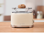 Cream toaster with a bread roll on the warming rack, on a wooden table.