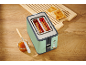 Mint-colored toaster with toast, jam, and butter knife on a wooden table.