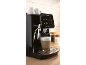 Black automatic coffee machine with touch screen, brewing a latte in a modern kitchen.