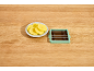 Sliced potatoes on a plate and a vegetable slicer on a wooden table.