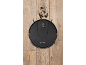 Black robot vacuum cleaner on a wooden floor, with dirt in front of it.