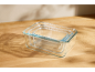 Set of three glass food storage containers, nested inside each other, on a wooden surface.