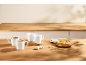 White mugs with hot drinks, cookies, and a lemon tart on a wooden table.