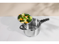 Stainless steel pressure cooker with a steamer basket filled with assorted vegetables.