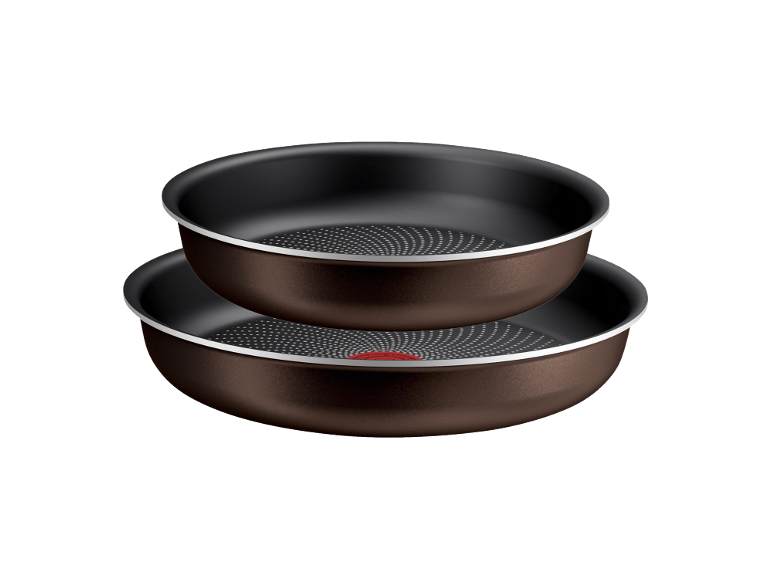 Two brown non-stick frying pans with dotted bottoms, stacked on top of each other.