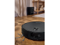 Robotic vacuum cleaner on a wooden floor, with a charging station in the background.