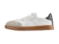 White leather sneakers with a brown rubber sole and a grey suede front.