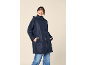 Smiling woman in a navy blue hooded raincoat and jeans.