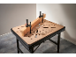 Workbench with a perforated top and a piece of wood clamped in place.