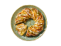 Pistachio braided bread with glaze on a turquoise plate.