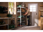 Man organizing tools on storage shelves in a workshop.