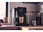 Automatic coffee machine with a latte in a glass, on a kitchen counter.