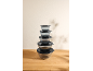 Stack of five clear mixing bowls with black lids on a wooden surface.