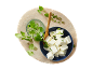 Feta cheese cubes with fresh oregano and chopped spring onions on a wooden board.